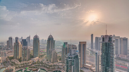 Obraz premium Aerial top view of sunrise in Dubai Marina timelapse. Modern towers and traffic on the road