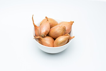 Chalotas frescas en cuenco blanco sobre fondo blanco