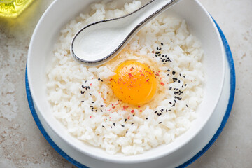 Tamago kake gohan or warm rice mixed with a raw chicken egg, horizontal shot, middle close-up, selective focus