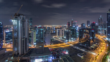 Fototapeta premium Aerial view of illuminated buildings and high traffic in modern Dubai city, United Arab Emirates Timelapse Aerial
