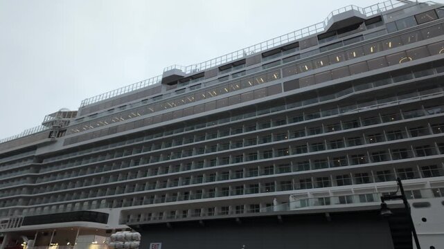 Gimbal close-up panning shot of a cruise ship in port during a cloudy day in Juneau, Alaska. 4K