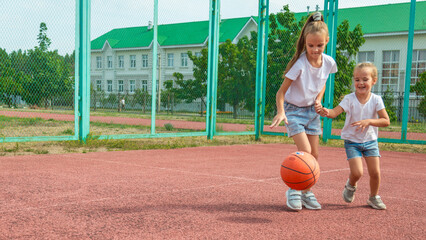 summer vacation, sport, games and friendship concept - happy children playing basketball outdoors
