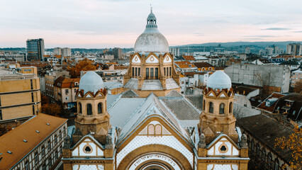 Aerial view of the striking Novi Sad Synagogue's dome and intricate architectural details amidst the city's skyline under a muted winter sky, Novi Sad, Vojvodina, Serbia.