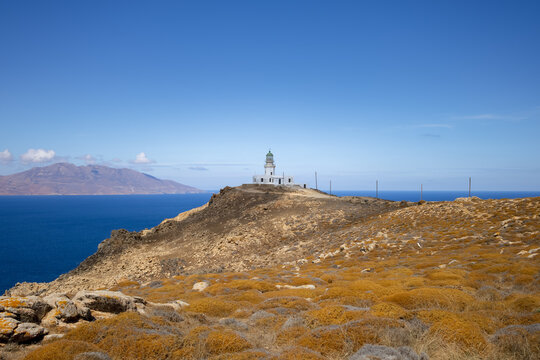 Armenistis Lighthouse, Mykonos, Greece. mediterranean seascape with rocky cliff deep blue see and lighthouse on the top. navigation concept. greek