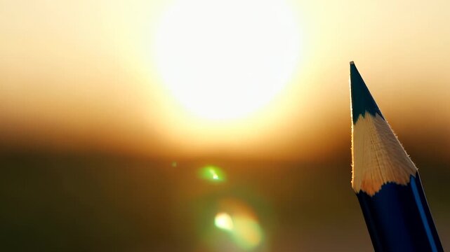 A sharp pencil points towards the bright sun, creating a vibrant atmosphere. The sunlight illuminates the pencil, emphasizing the connection between creativity and nature.