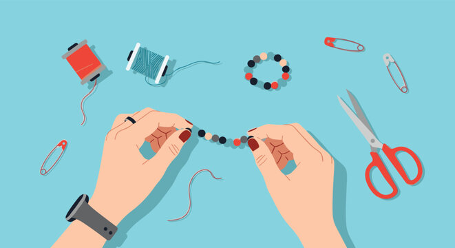 Top-down view of hands making a beaded bracelet with crafting supplies like thread and scissors in a DIY hobby illustration.
