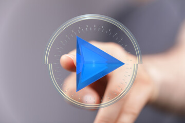 A hand interacting with a digital play button icon, representing media, technology, and futuristic interfaces. Perfect for concepts o