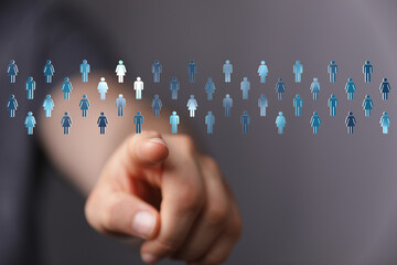 Hand pointing towards a group of people icons on a blurred background symbolizing teamwork recruitment and business networking. Concept of a cho