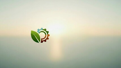 Low poly eco-industrial logo with green leaf and multicolored gears against soft blurred ocean sunset background. 