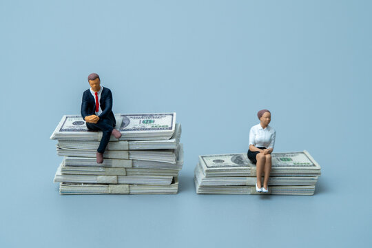 Man and woman figures sitting on unequal stacks of dollar bills. Gender pay gap, income inequality, financial disparity, and salary discrimination concept.