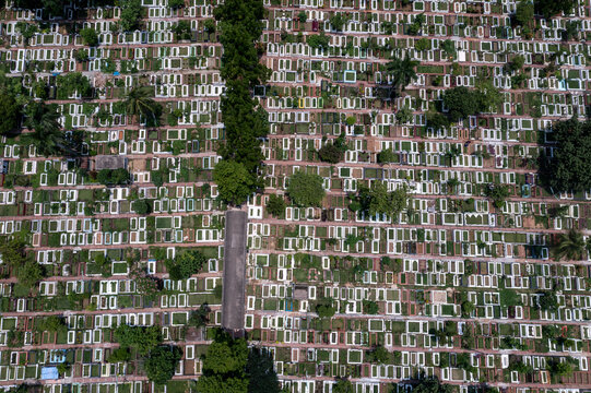 Aerial view of countless graves and headstones stand in stark uniformity against patches of green, creating a somber landscape at Azimpur Graveyard, Dhaka, Dhaka Division, Bangladesh.