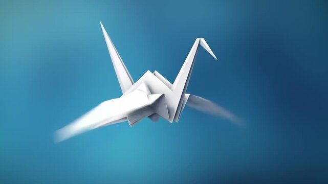 White Origami Crane Flying with Flapping Wings in Slow Motion on Blue Background, 4K. Symbol of Peace, Hope, and Serenity, ideal for aspirations and tranquility concepts.