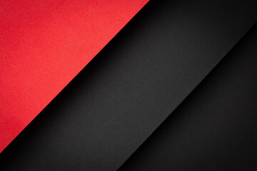 Red and black paper layers arranged in a diagonal pattern on a flat surface with clear lines and textures in a workspace setting