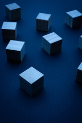 Wooden blocks arranged on a dark surface illuminated by blue light in a creative setup