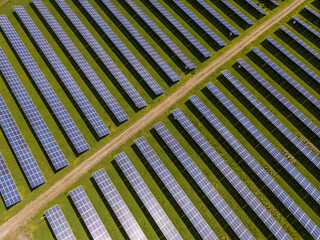 Aerial view of solar panels in neat rows against a background of green grass, creating a striking visual contrast, Perth, Scotland, United Kingdom.