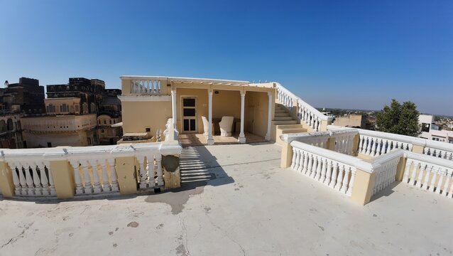 Exterior View of the Historic Mandawa Fort Rooftop Featuring Heritage Architecture and Vibrant Yellow Walls under a Clear Blue Sky