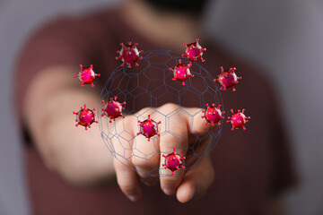 Conceptual image of a hand protecting a collection of viruses with a shield. Represents healthcare, safety, an