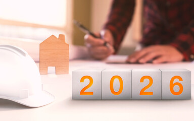 Happy New Year 2026. Construction and Industry.White Helmet and a numbered concrete cube on the desk of an engineer or architect.  construction industry concept.
