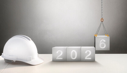 Happy New Year 2026 Construction and Industry. White Helmet and a numbered concrete cube on the desk of an engineer or construction worker. building with Cranes construction concept.