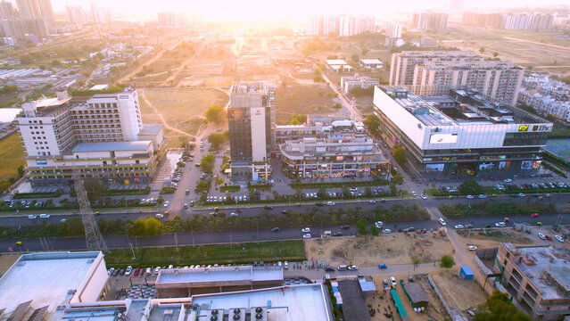 Aerial drone shot flying towards 3 reach roads elan shopping malls with sunlight coming from back showing the retail shopping markets available in India