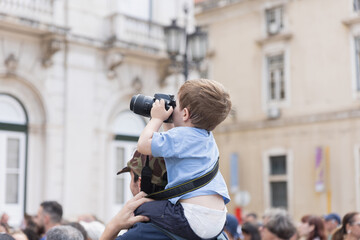 Little boy on shoulders learning photography skills