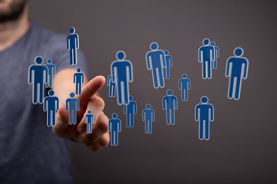 Hand reaching out to interact with a network of people icons, representing social connection, teamwork and coll