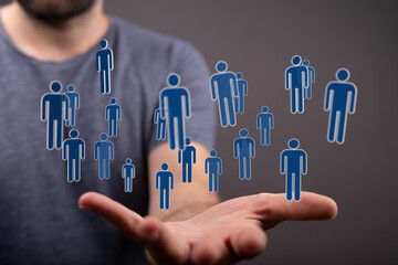 Image of human figures floating above a hand. Represents community, society, teamwork, and connection. Ideal fo