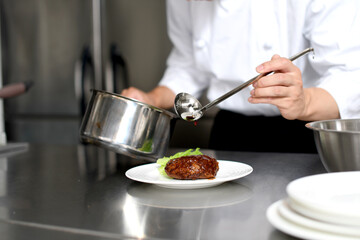 シェフが料理を丁寧に盛り付ける調理風景