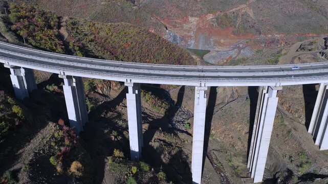 Aerial video of the A1 motorway viaduct curving through the rugged hills of Kolsh in Kuk&euml;s County of Northern Albania. 