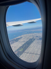 Fototapeta premium Take off from San Francisco airport with a view over the city from above showing the residential areas, downtown skyscrapers and the Bridge