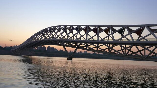 Atal Pedestrian Bridge Ahmedabad &ndash; modern steel arch bridge over river at sunset