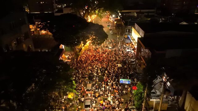 aerial view of a partying crowd in a busy street in Sao Jose dos Campos, countryside of Sao Paulo state in Brazil