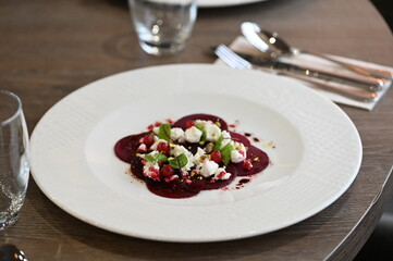 beetroot carpaccio served on a white plate, close-up of modern vegetarian dish in a restaurant, elegant food presentation, healthy gourmet cuisine,