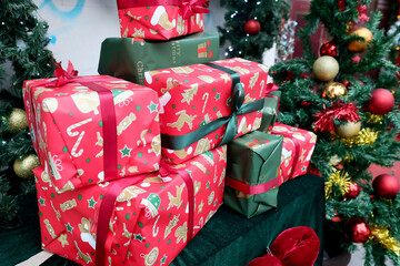 Colored presents gift for Christmas, new year celebration and Christmas tree with colored decorations in the backgrounds.
