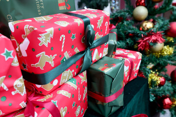 Colored presents gift for Christmas, new year celebration and Christmas tree with colored decorations in the backgrounds.
