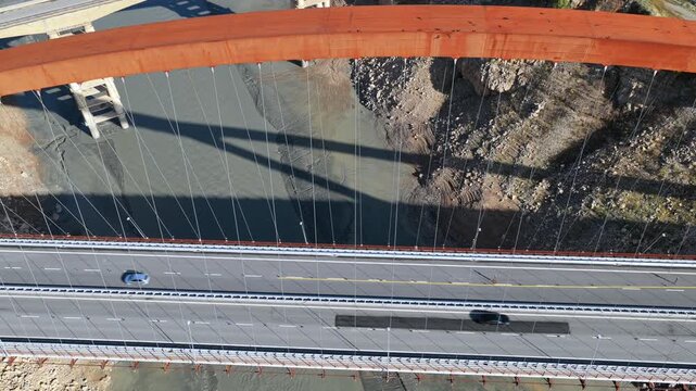 Top-down aerial video of the Kuk&euml;s Bridge stretching across the Drin River with a dry riverbed in Northern Albania. 