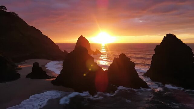 The sun sets over the ocean, casting a warm glow on the rocky shoreline. Jagged cliffs frame the scene as the sun dips below the horizon, reflecting on the calm water's surface.