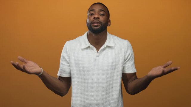 Man with palms up hands gesture in studio direct gaze; questioning uncertainty introspection reflection.