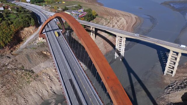 Aerial video of Kukesi Bridge with the rust-colored arch structure and the old Kuk&euml;s Bridge next to it. 