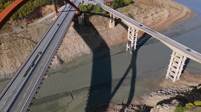 Aerial video of Kukesi Bridge with the rust-colored arch structure and the old Kuk&euml;s Bridge next to it. 