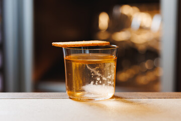 Amber Drink with Biscuit Garnish on a Bar Counter