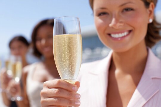 Friends toast drinks at a sunny outdoor event - Powered by Adobe