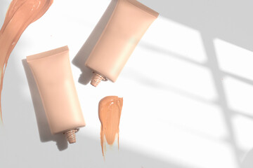 foundation primer cream lotion cosmetic for makeup, product mockup packaging tube bottle in flat lay close-up view
