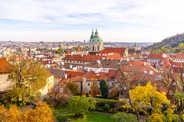Fototapeta premium Autumn in Praha. Red orange old tile roofs architecture in Prague Czech Republic Old house building top view. Trees cityscape
