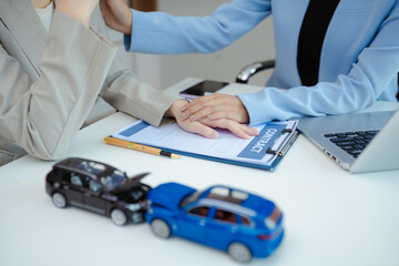 woman driving a car demands advice while an insurance agent examines the car's damage after an accident.