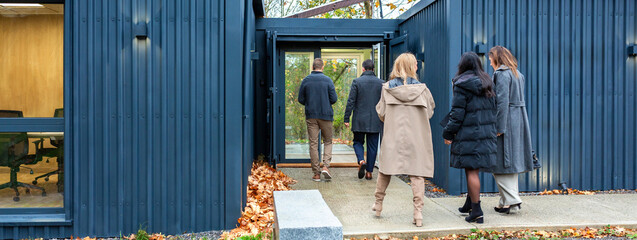 Banner of business professionals entering to coworking office building made with shipping containers