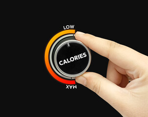 Minimizing calories intake concept shown by  the knob turning to the right with hand.