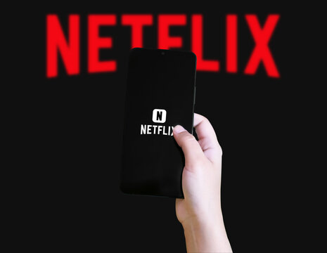 Smartphone application of streaming platform netflix concept with phone in hand, editorial background.