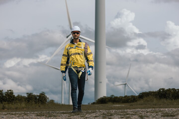 Wind turbine technician in protective gear and harness preparing for maintenance work, representing renewable energy, safety procedures, technical expertise in green energy.