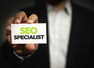 SEO Specialist showing card with typography close up. Website, ranking, profession.
